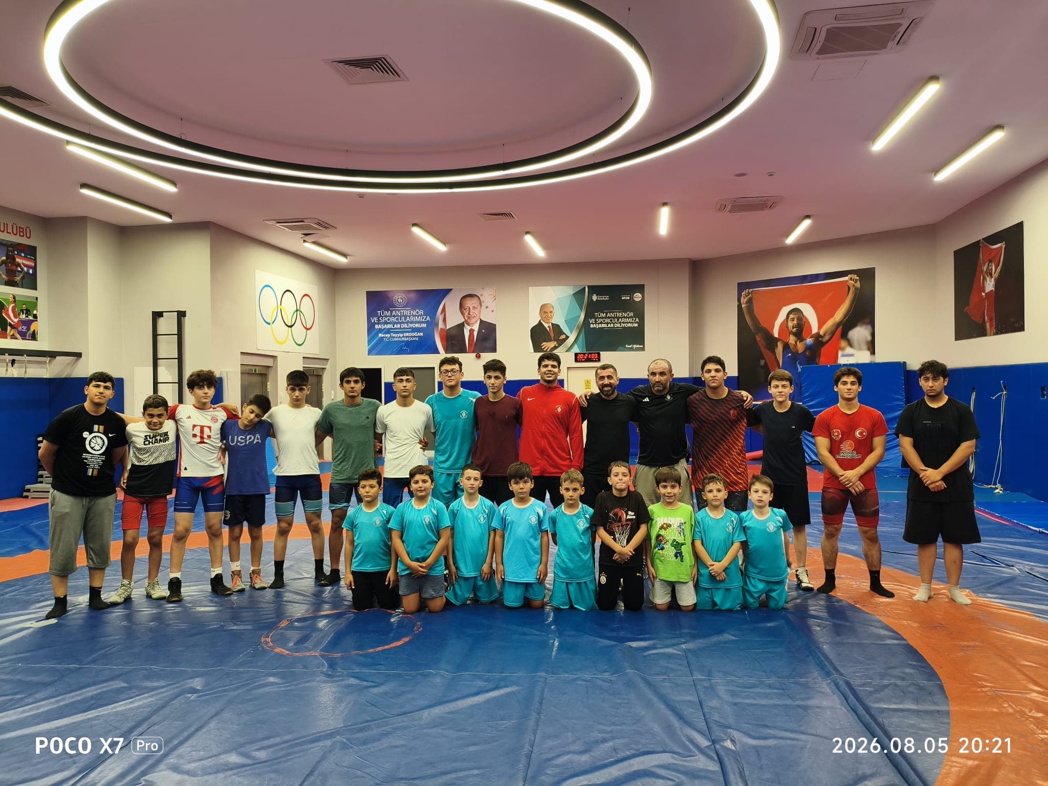 Kadir Hoca Güreş takımı, antrenörler ve sporcular salonda toplu fotoğraf